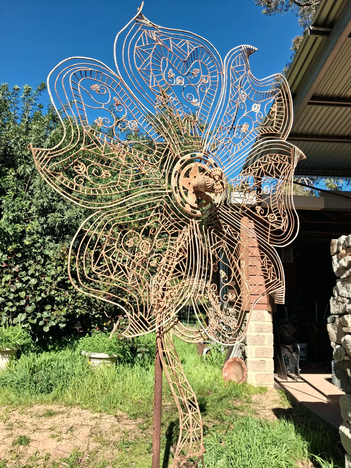 A large flower formed from drawn steel wire standing in a garden